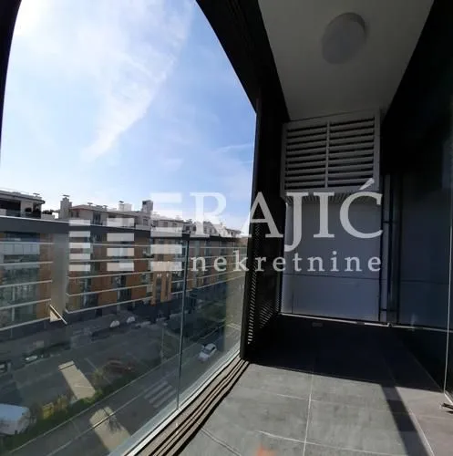 Modern balcony with a glass railing and neighborhood view.