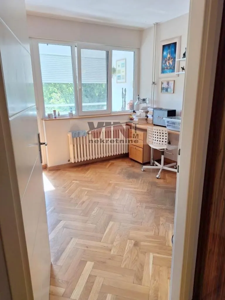 Smaller room with a desk and parquet flooring.