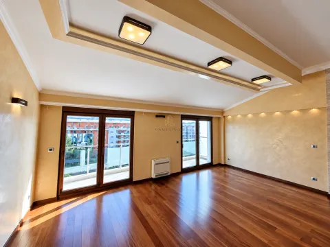 Spacious empty room with hardwood flooring, drop ceiling, and balcony doors. - image 2