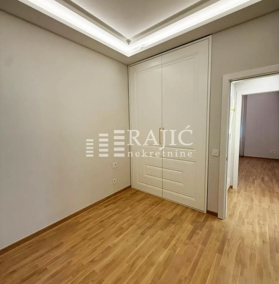 Empty room with a built-in wardrobe and wooden floor.