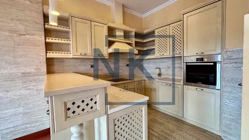 Kitchen with wooden cabinetry, a bar counter, and a built-in oven.