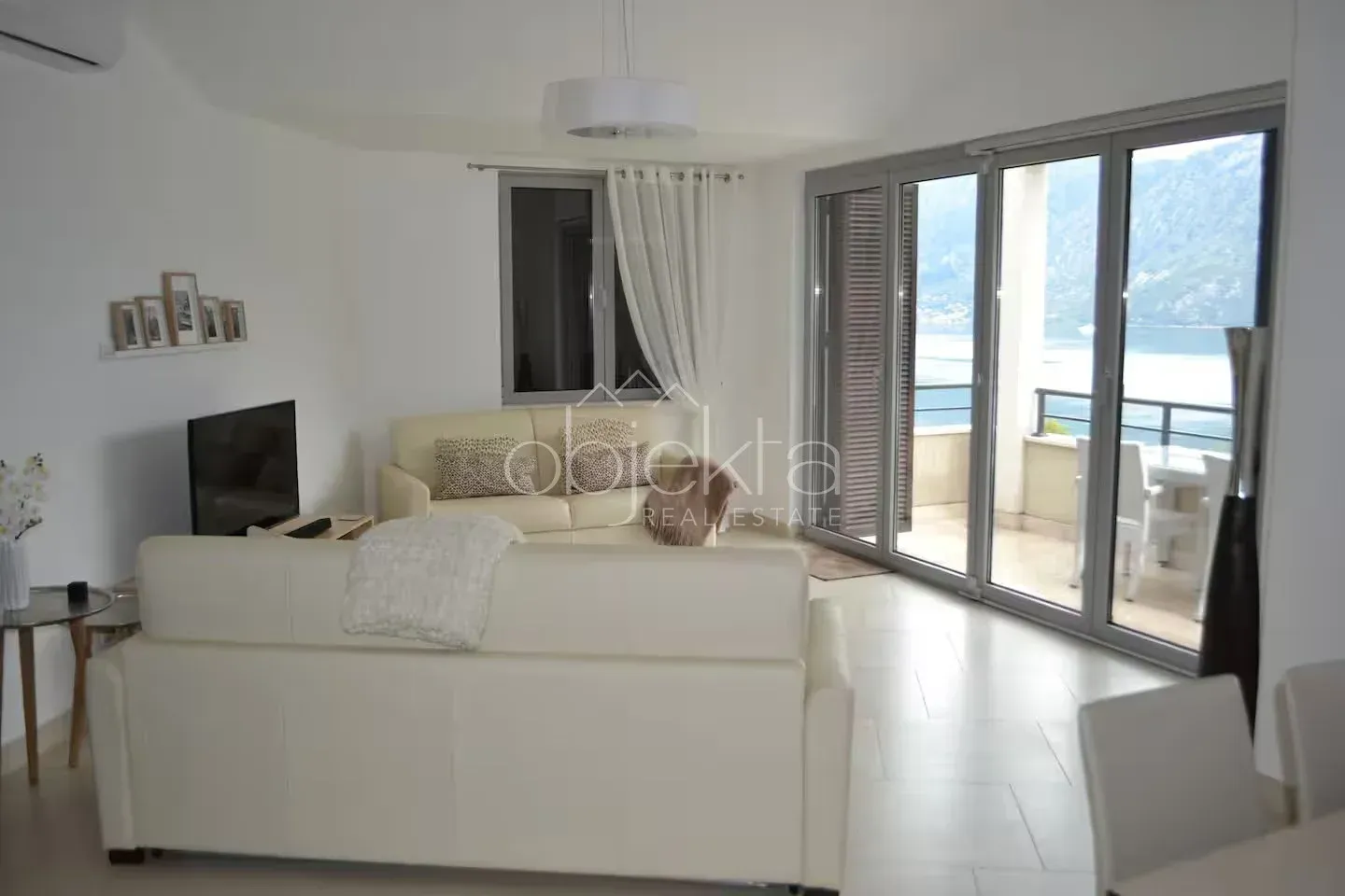 Living room with sofa and access to a terrace with sea view.