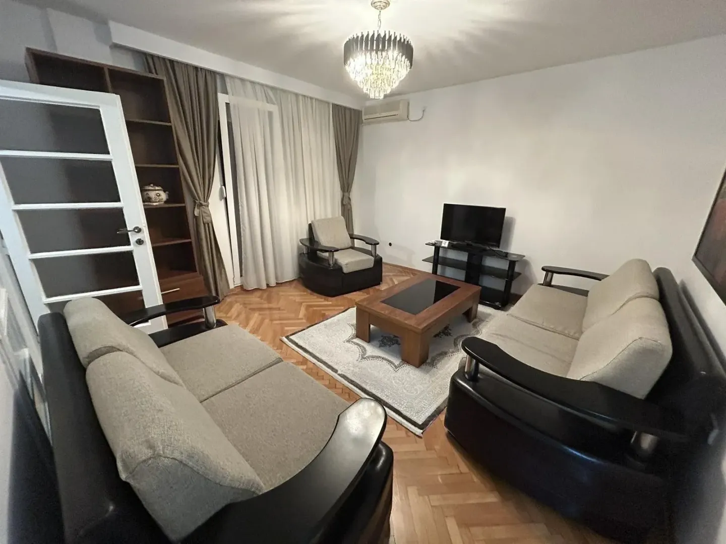Living room with a seating set, coffee table, and TV.