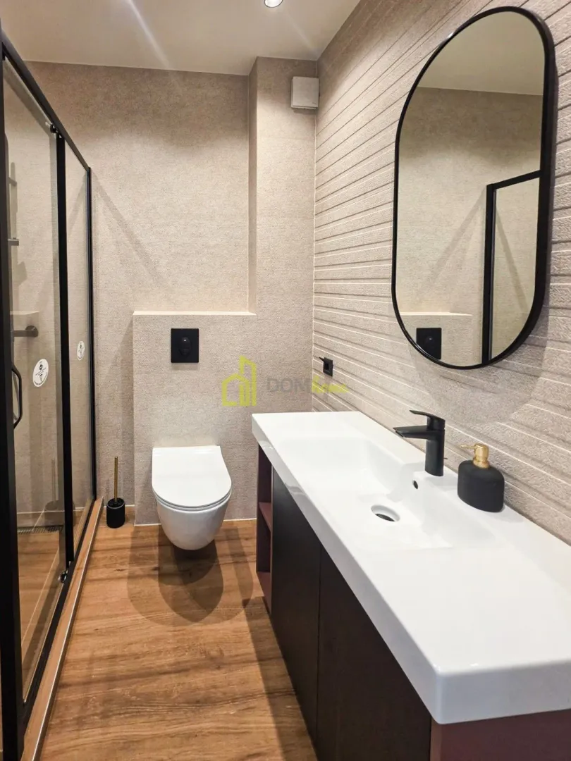 Moderne kupatilo sa tuš kabinom, umivaonikom i ugradnom wc šoljom.