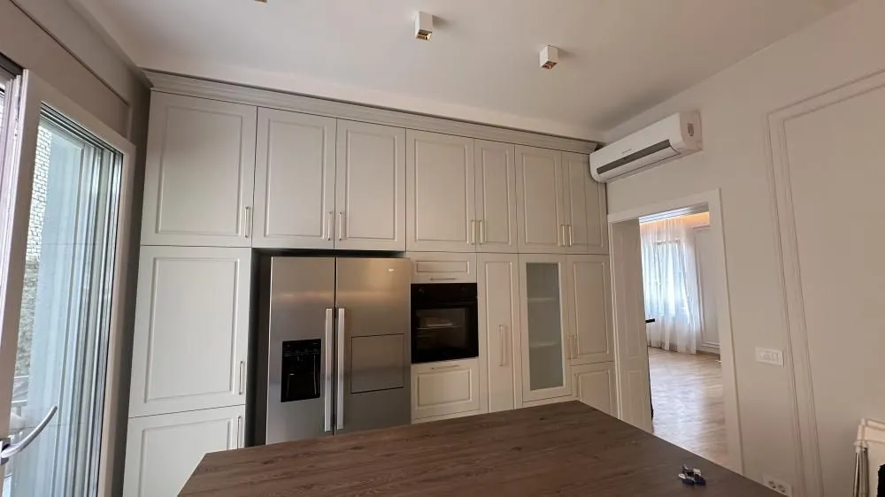 Kitchen with built-in cabinetry, refrigerator, and a kitchen island.