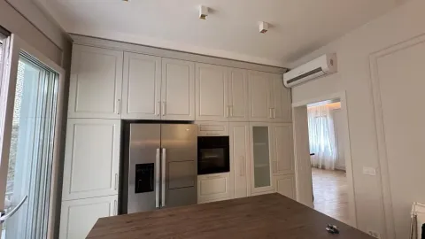 Kitchen with built-in cabinetry, refrigerator, and a kitchen island. - image 9