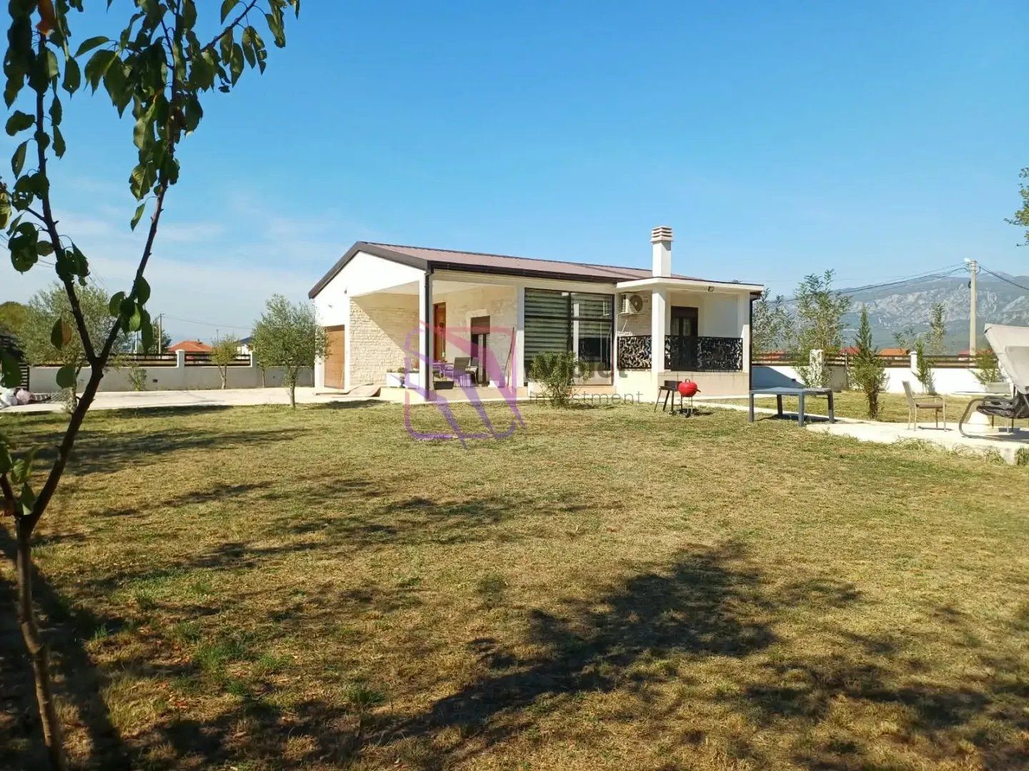 View of the house with a landscaped yard and lawn.