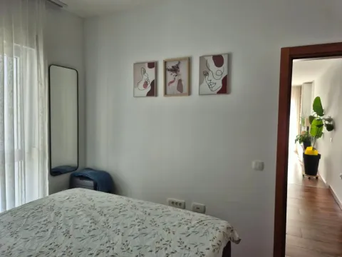 Furnished bedroom with a double bed and wall art. - image 17