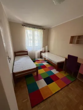Children's bedroom with two single beds, a desk, and a colorful rug. - image 6
