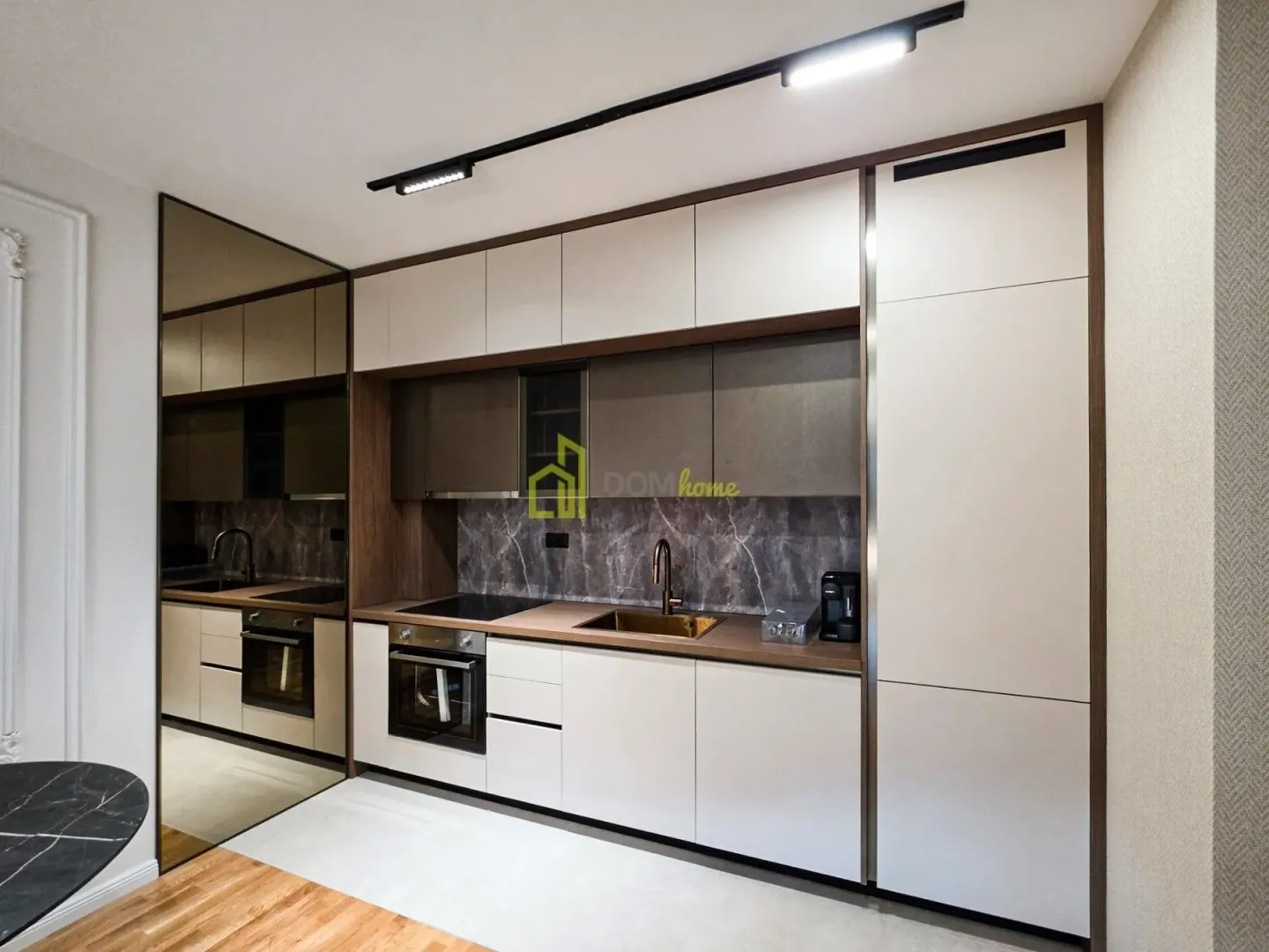 Modern kitchen with built-in units and a coffee machine.