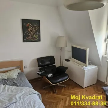 Spavaća soba sa krevetom, foteljom i televizorom. - image 4