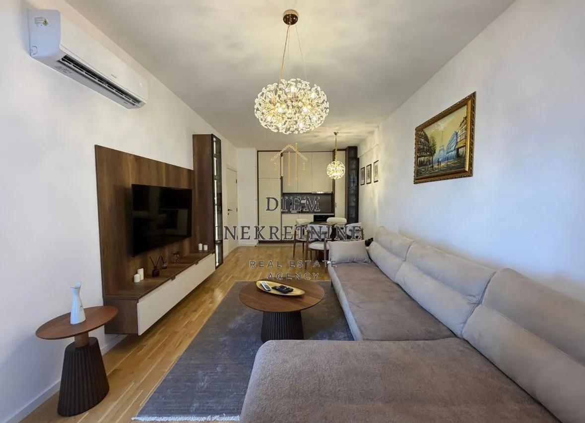 Modern and bright living room with a sofa and dining area in the background.