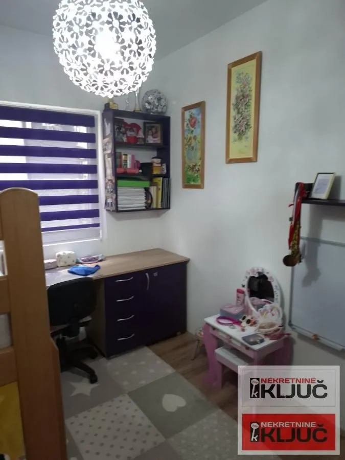 Dečja soba sa radnim stolom i policama.