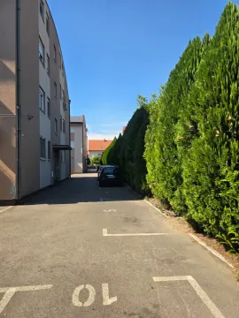Pogled na parking prostor i prilaz zgradi sa zelenilom. - image 6