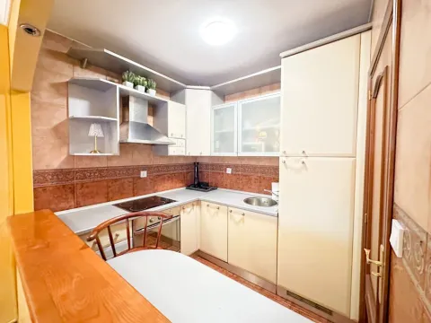 Smaller equipped kitchen with cabinetry and a dining area. - image 5