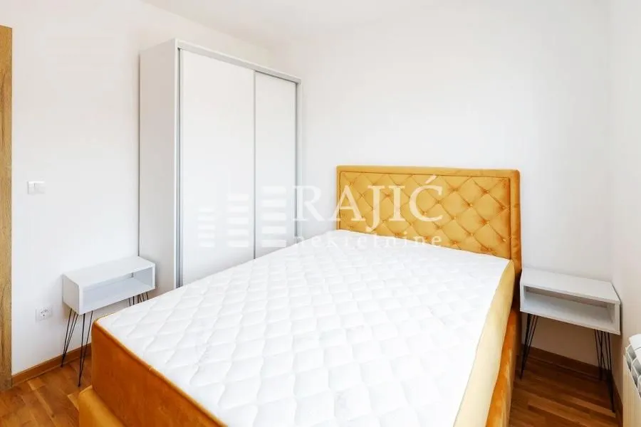 Bedroom with a double bed, white wardrobe, and bedside tables.