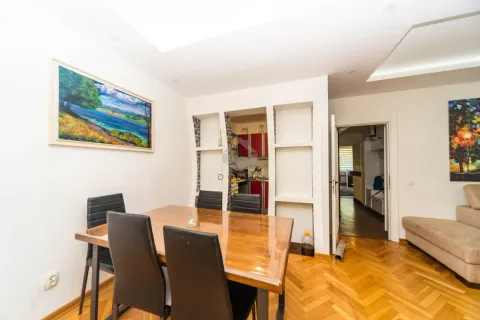 Trpezarija sa drvenim stolom i crnim stolicama u sklopu dnevnog boravka. - image 4