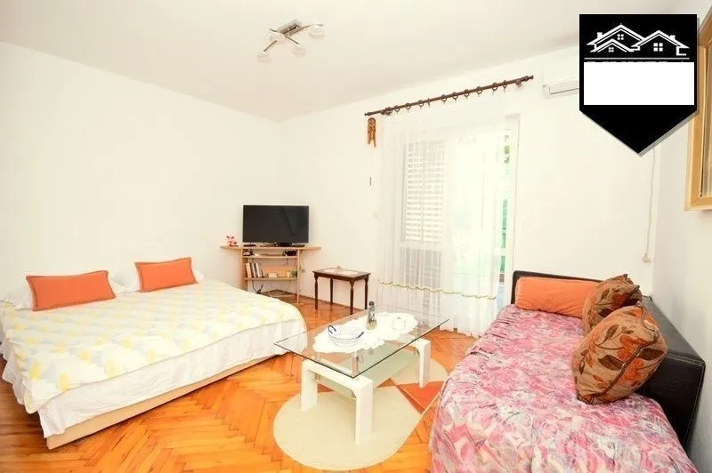 Furnished bedroom with a bed and a TV.