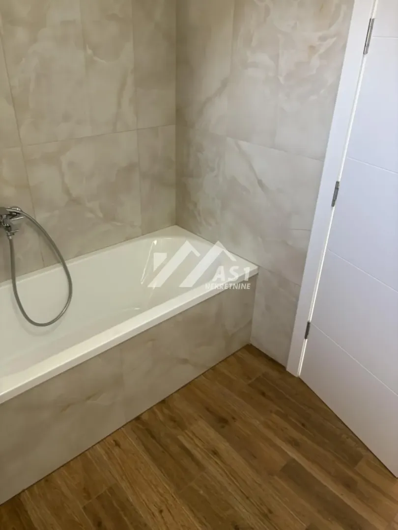 Bathroom with a built-in bathtub lined with ceramic tiles.