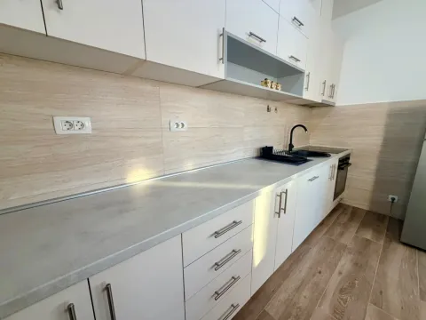 Moderna kuhinja sa bijelim elementima i radnom pločom. - image 7