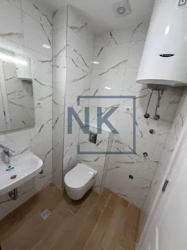 Manje kupatilo sa bijelim pločicama sa teksturom mermera, ugradnim WC šoljom, lavaboom i bojlerom. - image 6