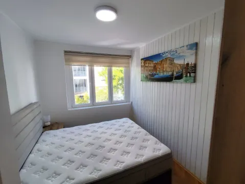 Spavaća soba sa bračnim krevetom, prozorom i zidnim panelima. - image 10