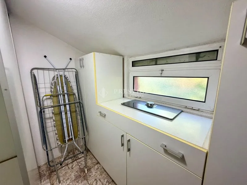 Small kitchen with a built-in hob and cabinets.