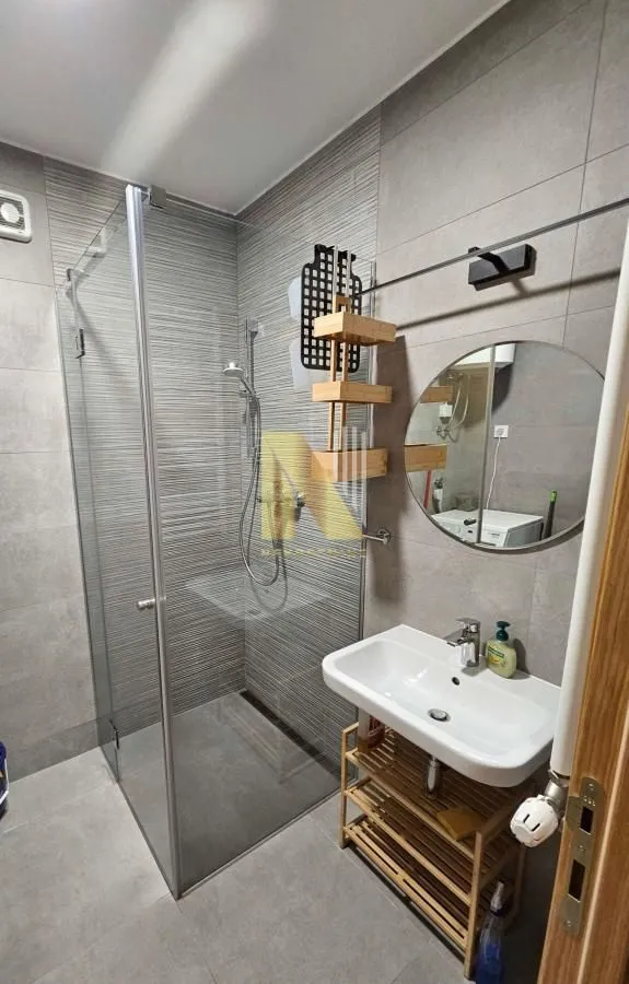 Modernly equipped bathroom with a shower cabin and a sink.