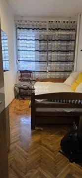 Furnished bedroom with a wooden bed and parquet flooring. - image 13