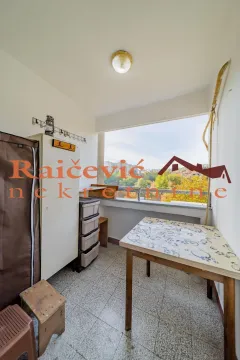 Natkriveni balkon sa stolom, ormarićima i pogledom na naselje. - image 7