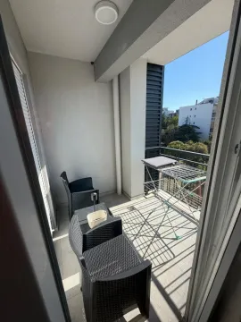 Natkriveni balkon opremljen sa garniturom za sedenje i stalkom za sušenje veša. - image 10