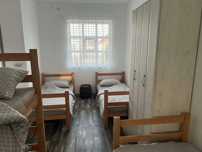 Bedroom with multiple wooden beds and a wardrobe.