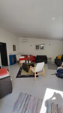 Prostrana dnevna soba sa garniturom za sedenje i stočićem. - image 7