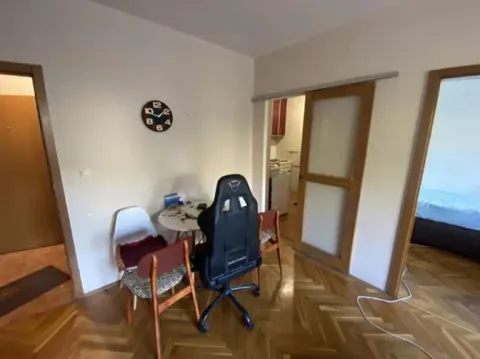 Trpezarija sa stolom, stolicama i zidnim satom u stanu. - image 6