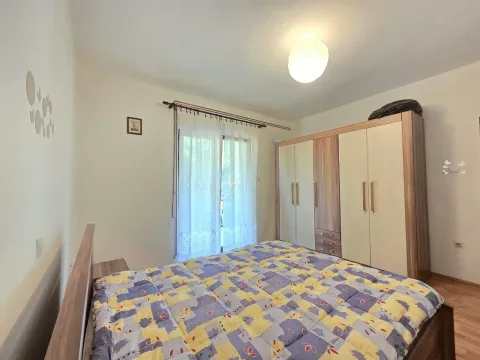 Spavaća soba sa bračnim krevetom, velikim garderoberom i prozorom sa zavjesama. - image 8