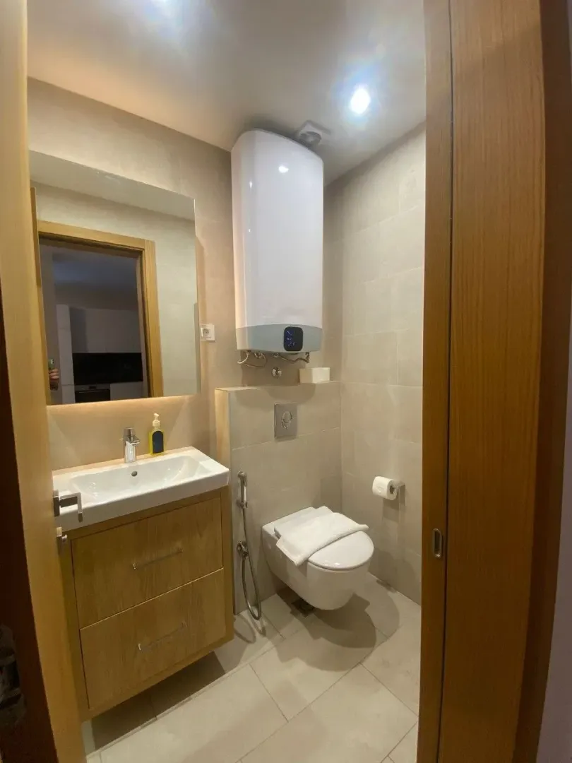 Moderno opremljeno kupatilo sa umivaonikom, WC šoljom i bojlerom.
