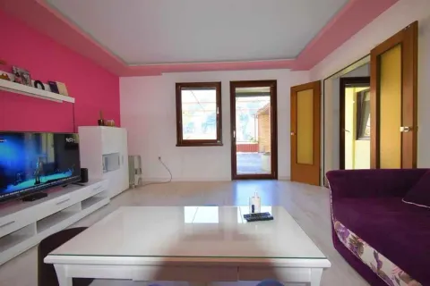 Bright living room with a pink accent wall and a glass coffee table. - image 6