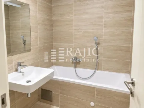 Modern bathroom with a sink and a bathtub tiled with ceramic tiles. - image 9