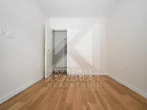 Empty room with hardwood flooring and an open door. - image 7