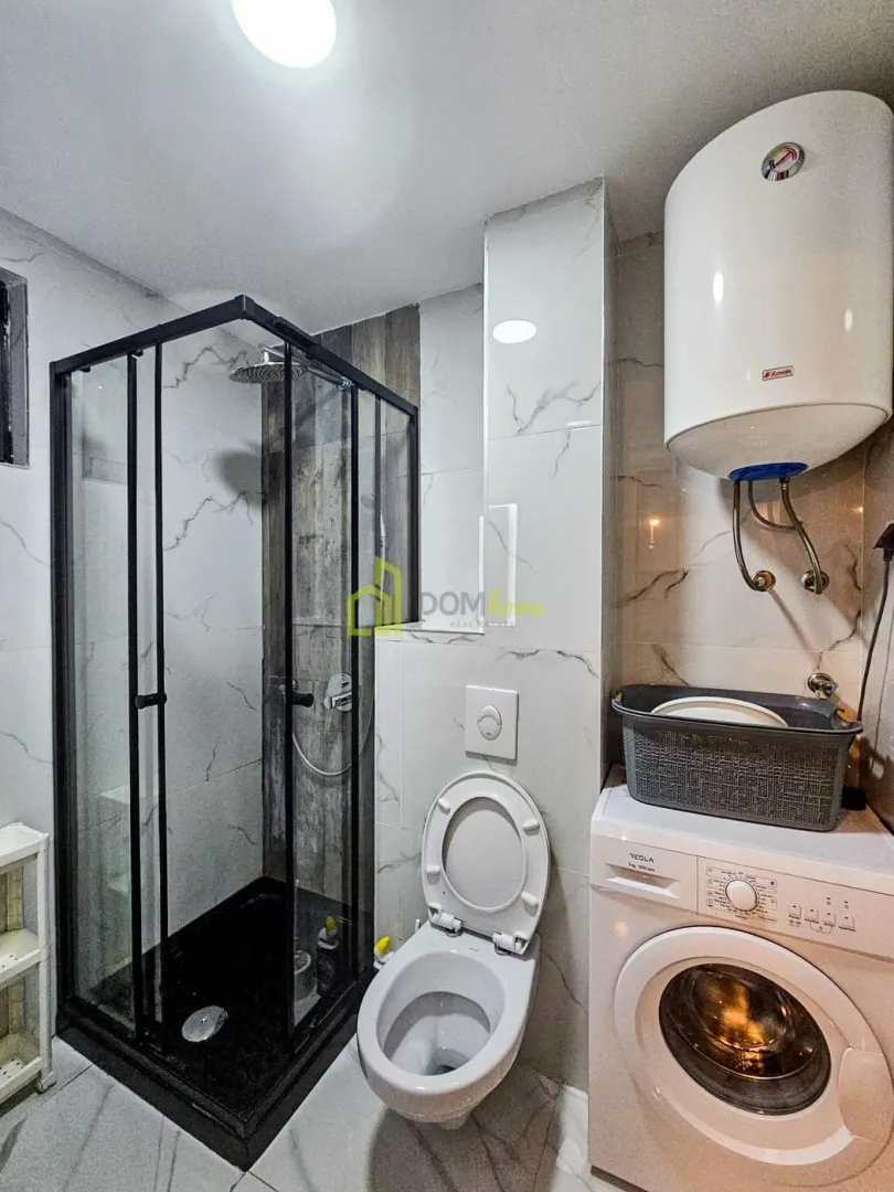Kupatilo sa tuš kabinom, WC šoljom, veš mašinom i bojlerom.