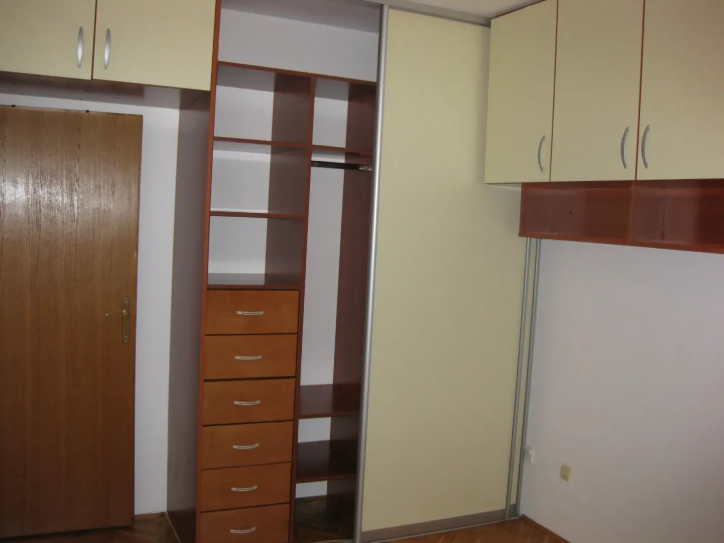 Smaller room with a built-in wardrobe and wooden elements.
