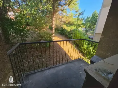Balkon sa metalnom ogradom i pogledom na zelenilo i drveće. - image 14