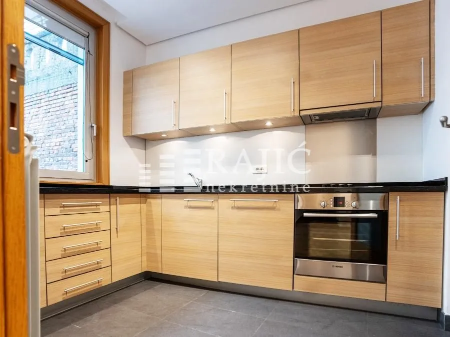Modern kitchen with wooden cabinets and built-in oven.