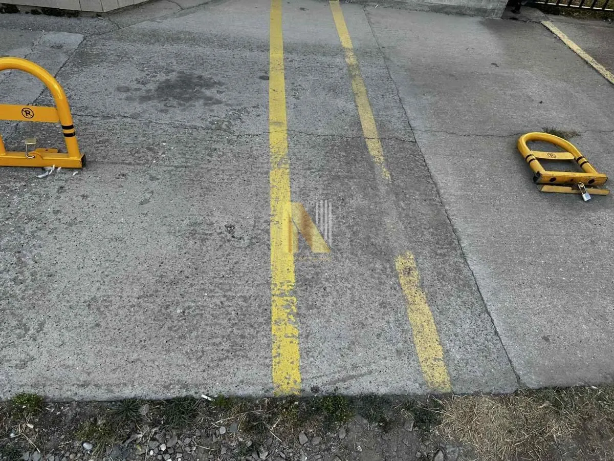 Asfaltirano parking mesto sa zaštitnom preprekom.
