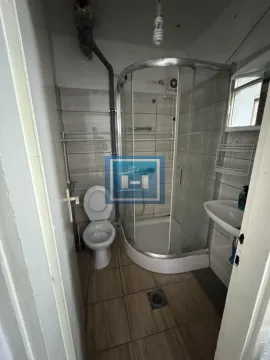 Small bathroom with a shower cabin, toilet, and washbasin. - image 3