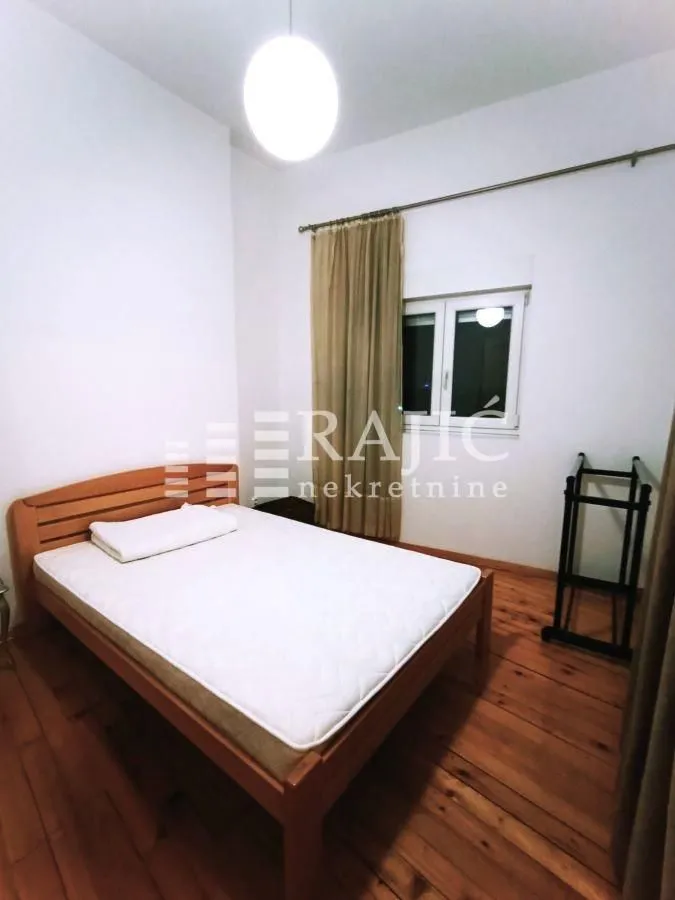 Bedroom with a wooden bed and a window.