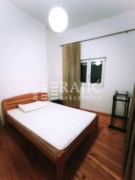 Bedroom with a wooden bed and a window. - image 3