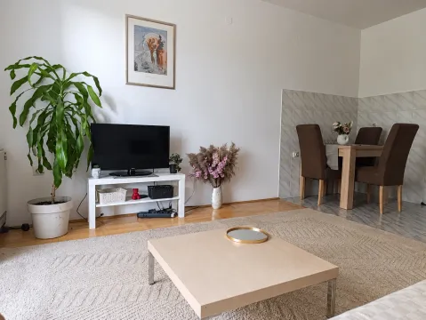 Dnevna soba sa TV-om, stočićem i trpezarijom u pozadini. - image 3