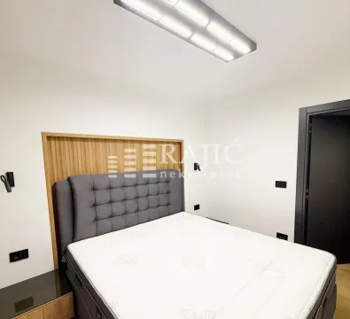 Modern bedroom with a double bed and wooden wall panel. - image 4