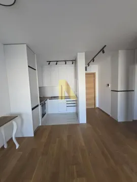 Moderna bela kuhinja u sklopu otvorenog prostora sa drvenim podom. - image 8